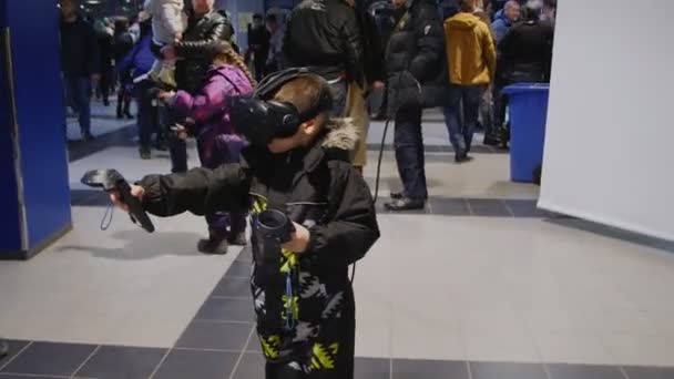 Μικρό αγόρι σε χειμωνιάτικα ρούχα παίζει βιντεοπαιχνίδι κοντά στην οθόνη — Αρχείο Βίντεο