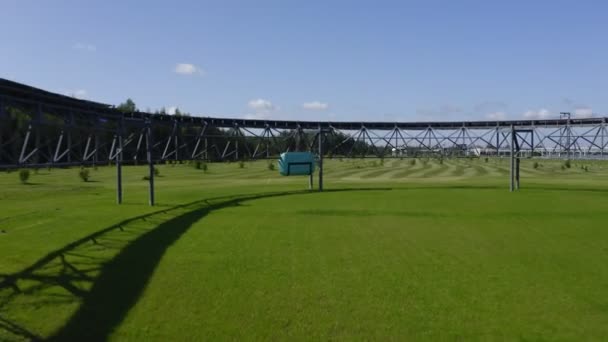 Unicar unidades a lo largo de puente de ferrocarril oval girar sobre el campo — Vídeos de Stock