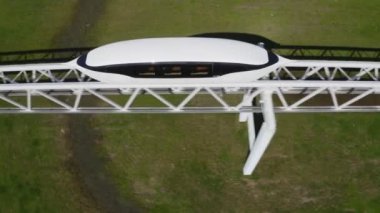 Skyway aracı üst geçitten tren yolu boyunca gidiyor.