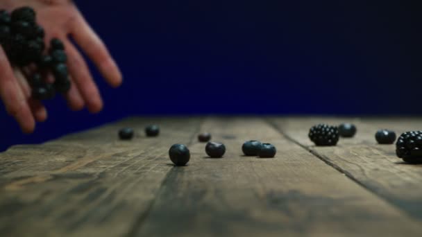 Vrouw strooit verschillende bessen op tafel slow motion — Stockvideo