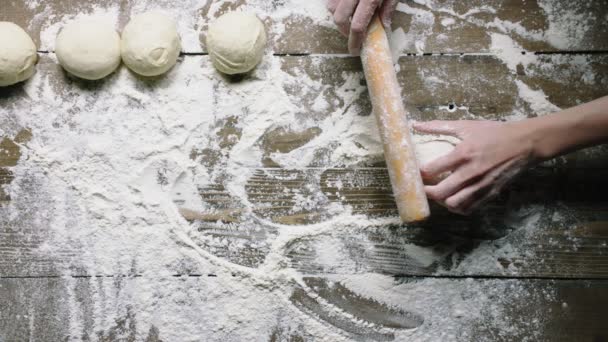 Пекарь катит кусок теста со штифтом верхнего вида замедленного движения — стоковое видео