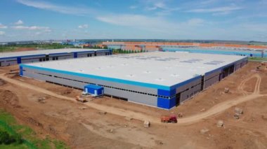 Kamyonlar inşaat alanındaki hava sahasında depo boyunca gidiyor.