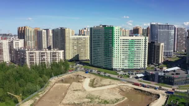 Sitio de construcción cerca del complejo de viviendas bajo el cielo azul superior — Vídeo de stock