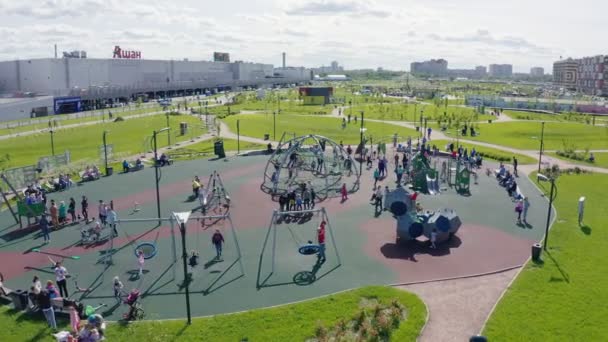 Happy children play on new playground in green park aerial — Stock Video