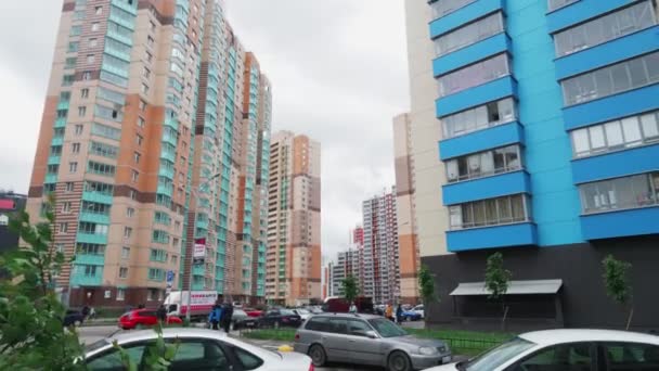 Bâtiments d'habitation et les gens sous le ciel gris ralenti — Video