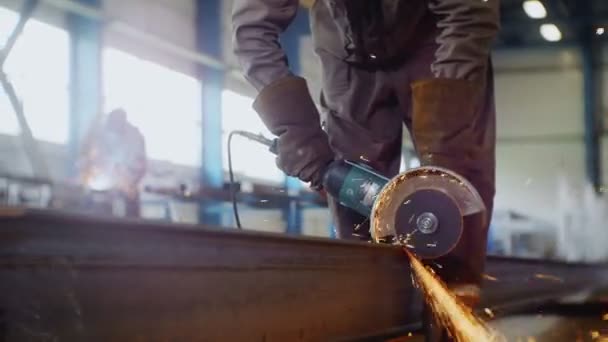 Worker cuts beam with saw at gas and oil refinery plant — Stock Video