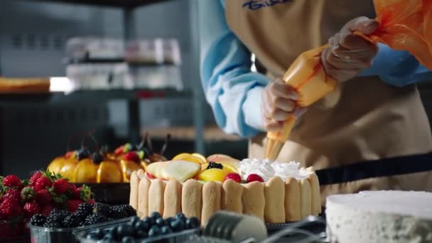 Confeiteiro coloca creme no bolo de frutas na mesa câmera lenta — Vídeo de Stock