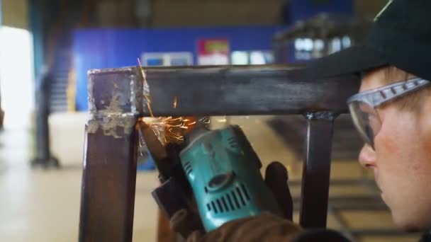 Worker in goggles grinds carcass at refinery plant closeup — Stock Video