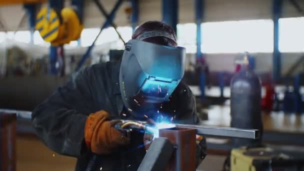 Feliz trabajador suelda canal de metal en taller de planta de refinería — Vídeo de stock