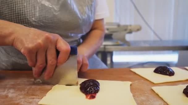 Vrouw maakt taarten met jam op houten tafel in winkel closeup — Stockvideo