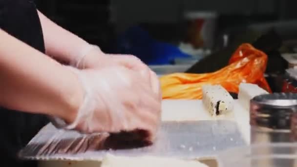 Șef în mănuși face rola de sushi gustoasă în bucătărie vedere de aproape — Videoclip de stoc
