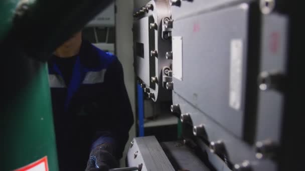 Empregado em uniforme azul monta skid de controle na planta — Vídeo de Stock