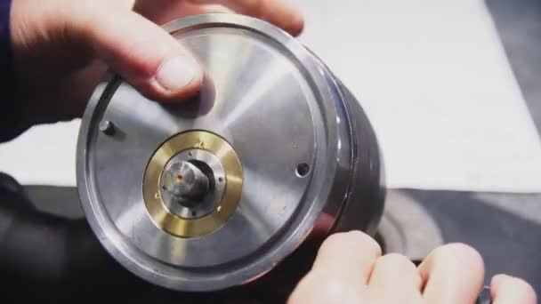 Werknemer met metalen detail voor controle slip aan tafel closeup — Stockvideo