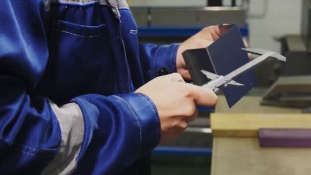 Trabajador calificado mide detalle de metal con herramienta en taller — Vídeo de stock