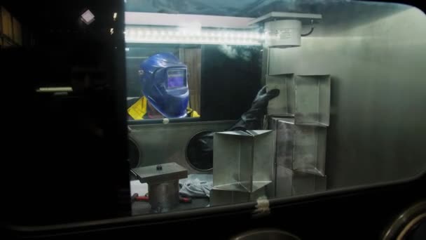 Pracovník v masce svařuje detaily v uzavřeném vzduchotěsném boxu v závodě — Stock video