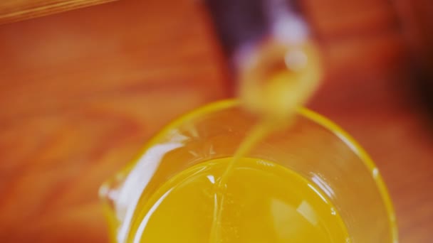 Menuangkan minyak kacang pinus ke gelas kimia di atas meja — Stok Video
