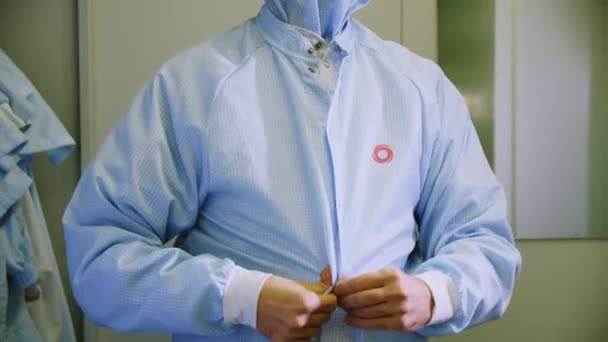 Employee puts on uniform shirt in changing room closeup — Stock Video