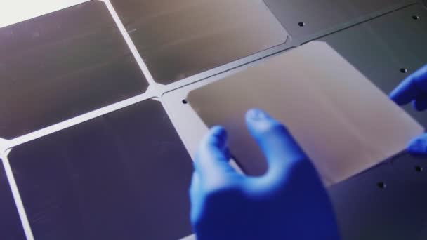 Person puts cell plate on solar panel in plant workshop — Stock Video