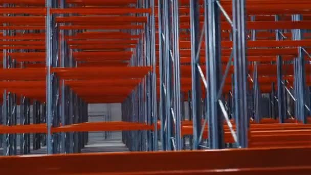 Motion past empty new racks with red planks in warehouse — Stock Video