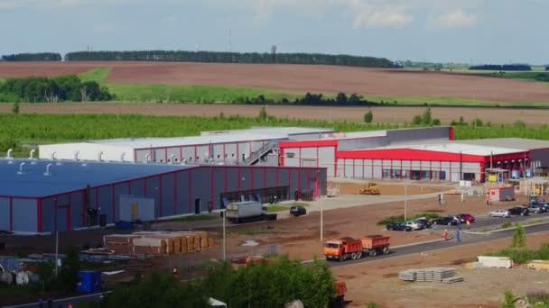 Camión rojo conduce a lo largo de la carretera cerca de edificios de almacén aéreo — Vídeos de Stock