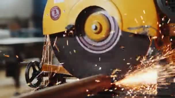 Worker cuts metal pipe with saw at production plant closeup — Stock Video