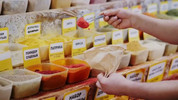 Kvinna sätter marken paprika i brun papperspåse nära displayen — Stockvideo