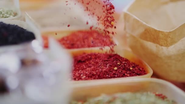 Жінка кладе сушені помідори в паперовий мішок біля дисплея магазину — стокове відео