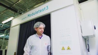 people go out from solar panel testing module in workshop