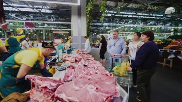 Butchers in aprons serve meat to customers at farmers market — 图库视频影像