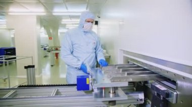 employee pulls out sheet from machine at solar panel plant