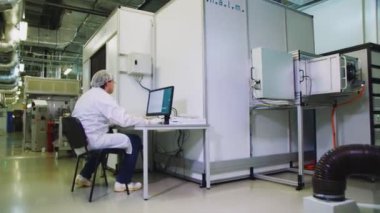 Mühendis güneş paneli test modülünün yanındaki bilgisayarda çalışıyor