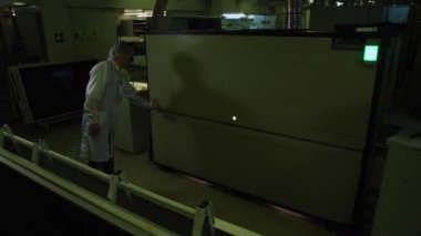 İşçi fabrikadaki güneş panelleri üretimi için makine açıyor