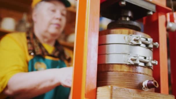 Kvinnlig säljare installerar pott till oljepressmaskin på marknaden — Stockvideo