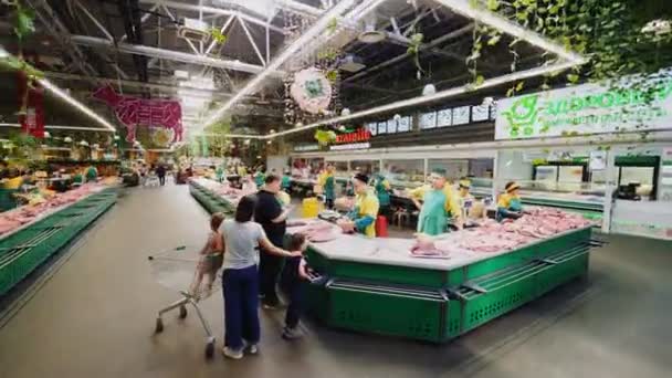 Семья покупает свежее мясо в отделе мясников — стоковое видео