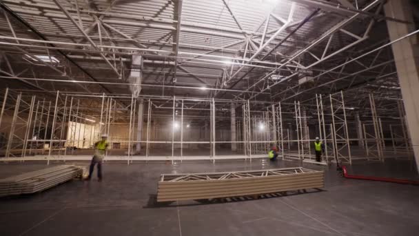 Team assembles large metal racks in storehouse timelapse — Stock Video