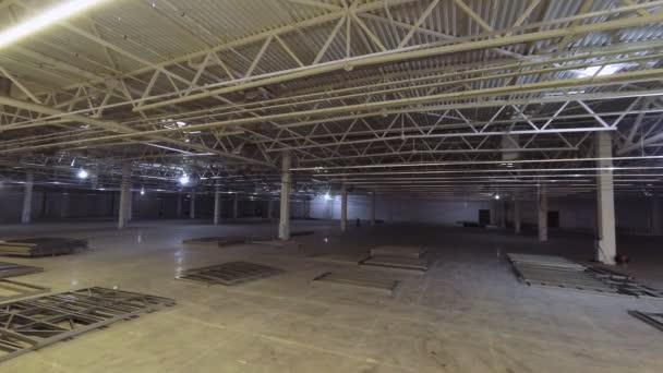Dělníci montují kovové konstrukce v prostorném skladu — Stock video
