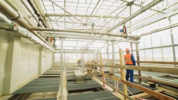 Мужчины собирают конструкции в торговом центре со стеклянными стенами — стоковое видео