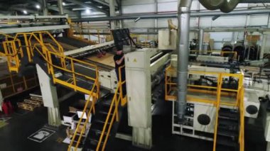 Kontrol panelinin yanındaki işçiyle üretim hattı boyunca hareket