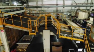 Taşıyıcı fabrikadaki karton çarşafları büker ve taşır