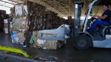 Forklift kamyonu depodaki taşıyıcıya atık bezi koydu.