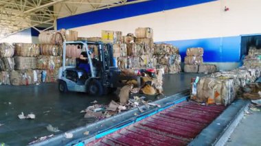 Forklift yükleyicisi depodaki taşıyıcıya atık kağıt taşır