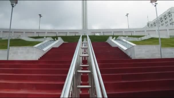 컵을 들고 높은 기념물로 이어지는 붉은 계단 — 비디오