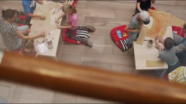 Des groupes d'enfants avec des professeurs peignent des figures animales aux tables — Video