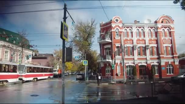 Young woman crosses street against old building on nasty day — 图库视频影像