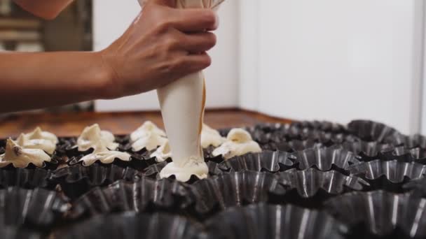 Confectioner fills baking forms with dough in workshop — Stock Video