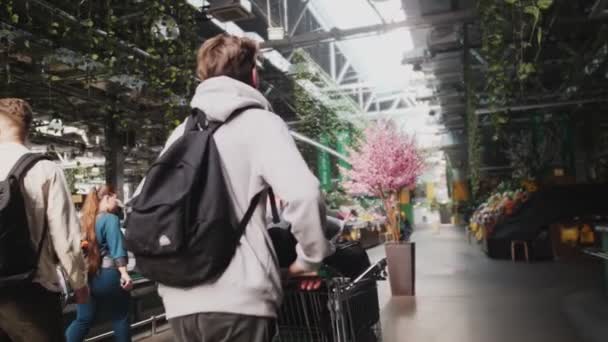 Człowiek z wózkiem spacery wzdłuż supermarketu slow motion — Wideo stockowe