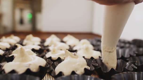 Vrouw vult vormen met deeg uit piping bag in bakkerij — Stockvideo