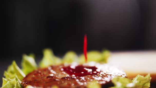 Заливая кетчуп на гамбургер в замедленной съемке на кухне — стоковое видео