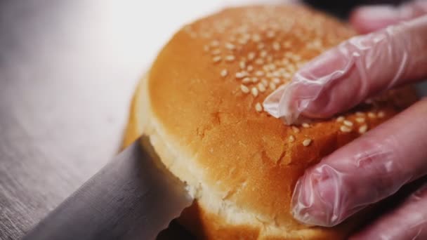 Šéfkuchař krájí hamburger měkké housky na kovovém stole zpomalený pohyb — Stock video