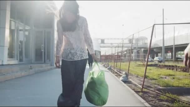 Dame en jupe longue promenades tenant grand sac le long de la rue de la ville — Video